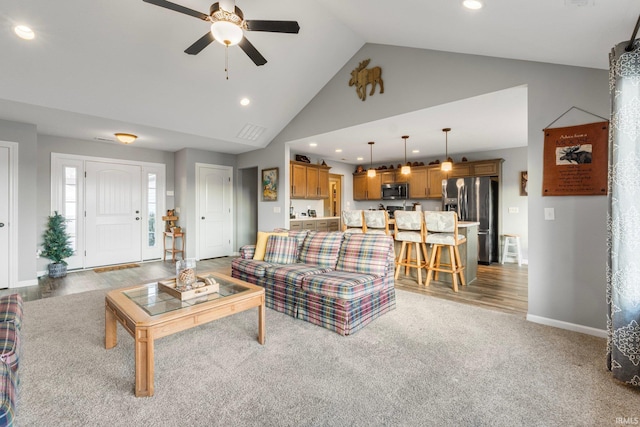 living room featuring ceiling fan, high vaulted ceiling, and light hardwood / wood-style flooring