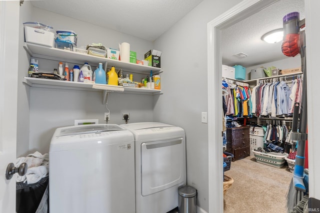 laundry area featuring washing machine and clothes dryer, carpet, and a textured ceiling