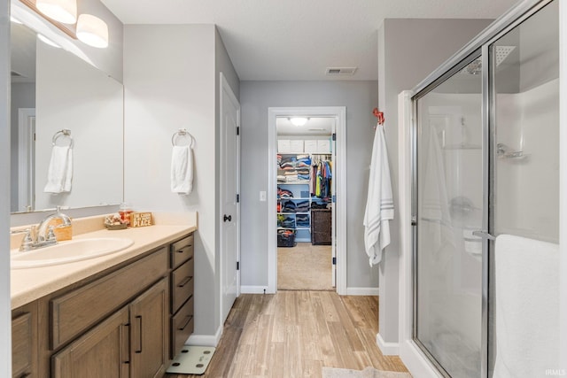 bathroom featuring vanity, hardwood / wood-style floors, and a shower with door