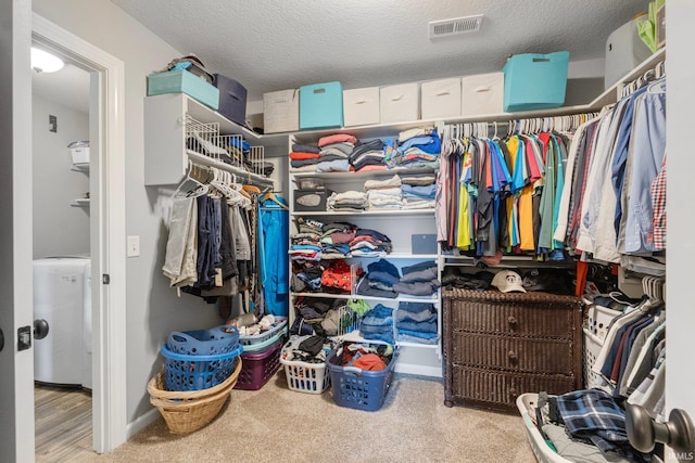 walk in closet with washer / clothes dryer and carpet floors