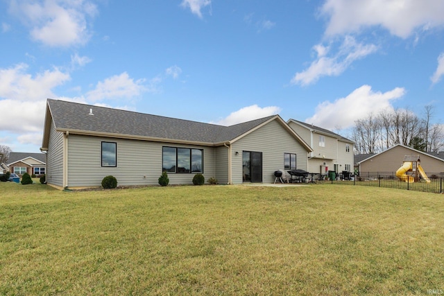 rear view of property featuring a yard, a patio, and a playground