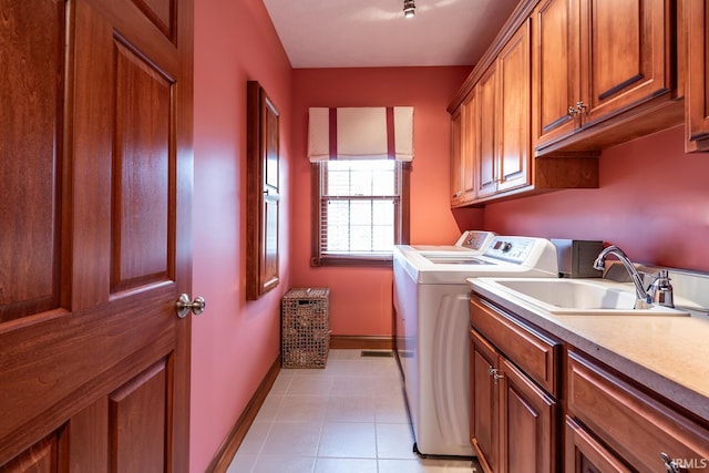 laundry room with washer and dryer, sink, light tile patterned floors, and cabinets