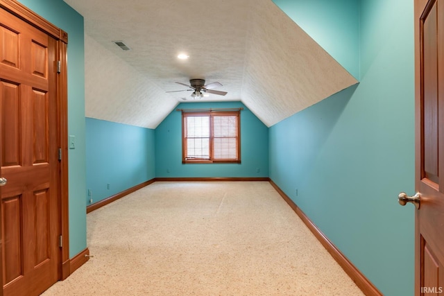 bonus room with vaulted ceiling, light colored carpet, ceiling fan, and a textured ceiling