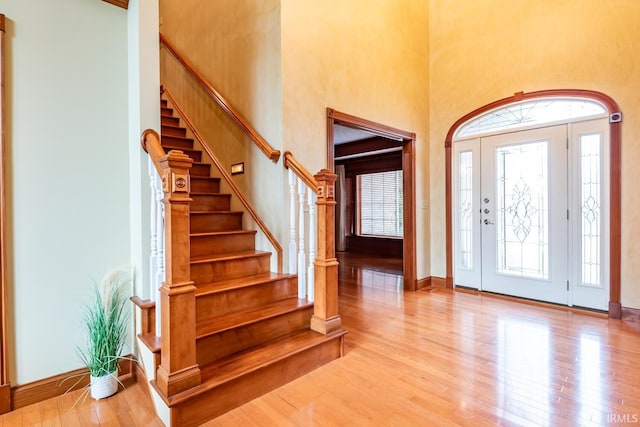 foyer entrance with a high ceiling and light wood-type flooring