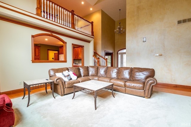 living room with a towering ceiling and light hardwood / wood-style floors