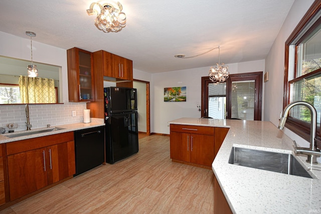 kitchen with a notable chandelier, sink, decorative light fixtures, and black appliances