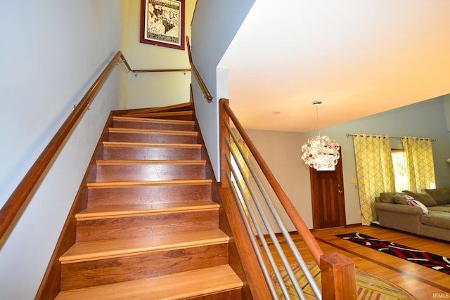 stairway featuring an inviting chandelier and hardwood / wood-style floors