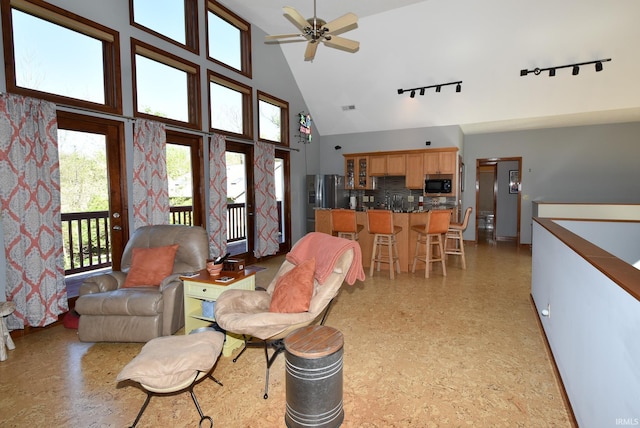 living room featuring ceiling fan and high vaulted ceiling