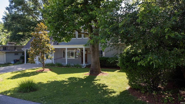 obstructed view of property featuring a front lawn, a carport, and covered porch