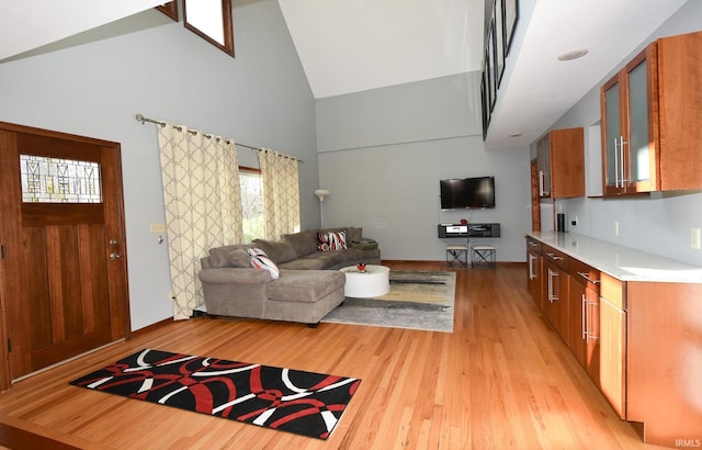 living room with high vaulted ceiling and light wood-type flooring