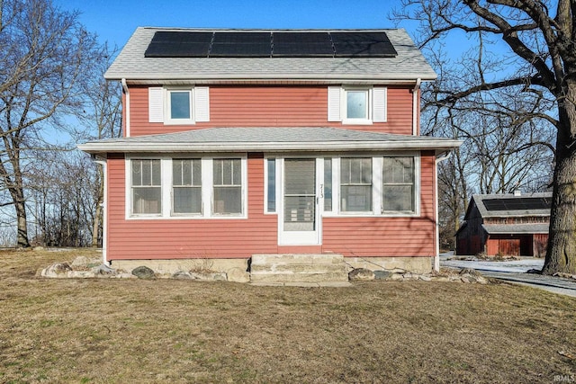 view of front of house with a front lawn and solar panels