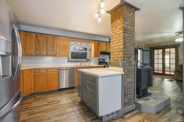 kitchen featuring sink, dark wood-type flooring, ceiling fan, stainless steel appliances, and decorative columns