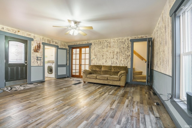 unfurnished living room featuring hardwood / wood-style flooring, ceiling fan, a wealth of natural light, washer / dryer, and french doors