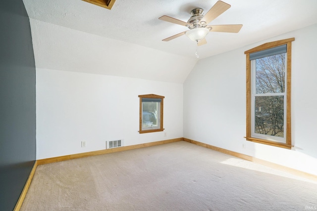 bonus room featuring lofted ceiling, ceiling fan, a textured ceiling, and carpet