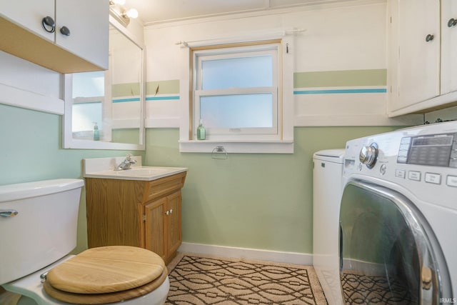 bathroom with vanity, toilet, and washing machine and dryer