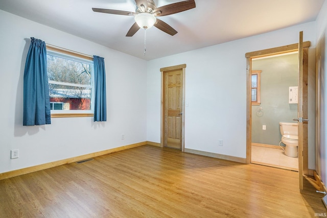 unfurnished bedroom featuring ensuite bath, light hardwood / wood-style floors, and ceiling fan