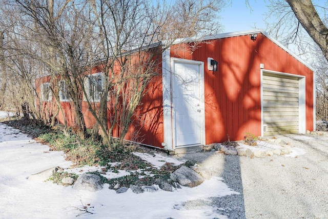 snow covered structure featuring a garage