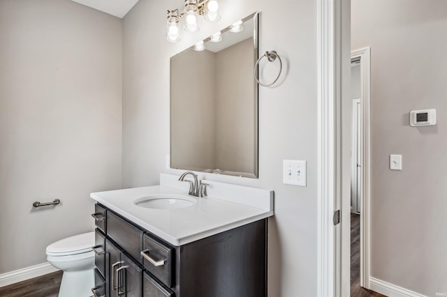 bathroom with hardwood / wood-style flooring, vanity, and toilet