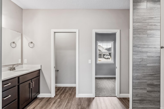 bathroom featuring hardwood / wood-style flooring, vanity, and a textured ceiling