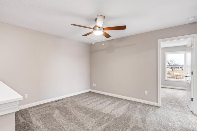 carpeted spare room featuring ceiling fan