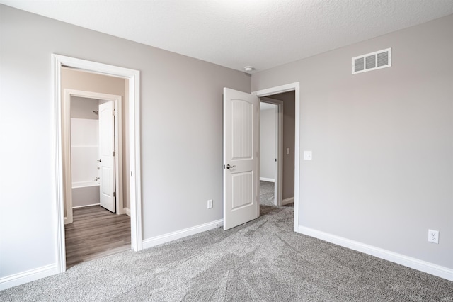 unfurnished bedroom with carpet flooring and a textured ceiling