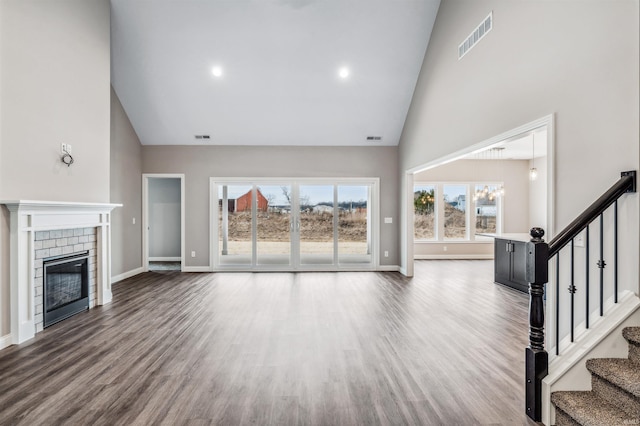 unfurnished living room featuring hardwood / wood-style floors and high vaulted ceiling