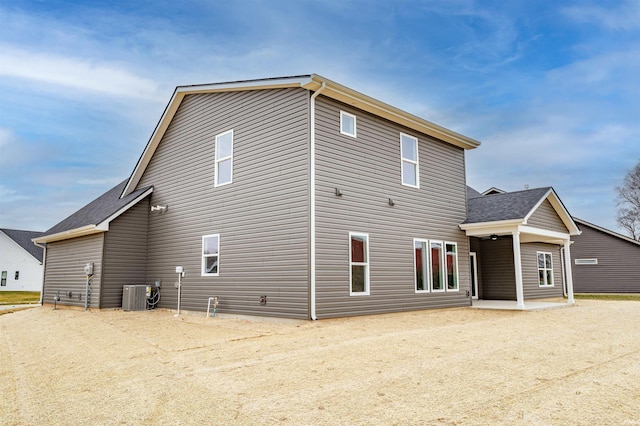 rear view of house with central AC unit and a patio