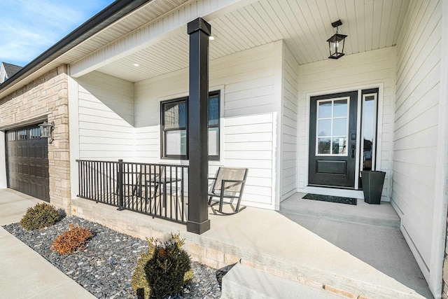 doorway to property with a porch and a garage