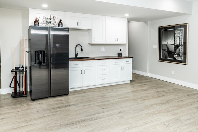 kitchen with white cabinetry, sink, light hardwood / wood-style floors, and stainless steel fridge with ice dispenser