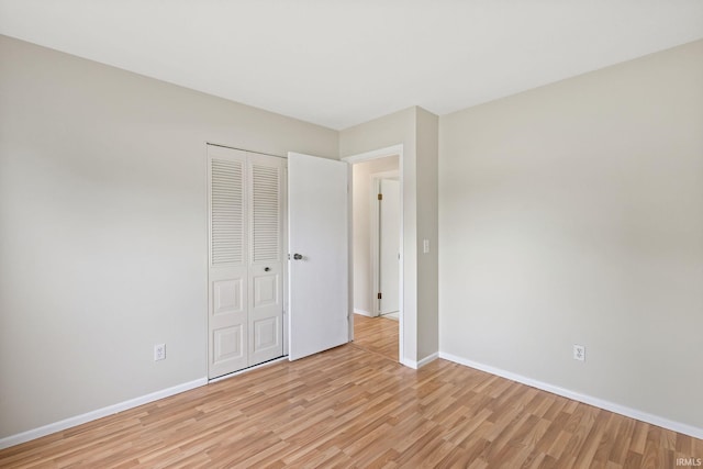 unfurnished bedroom featuring a closet and light hardwood / wood-style flooring