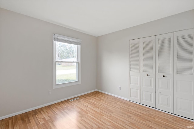 unfurnished bedroom with light hardwood / wood-style floors and a closet