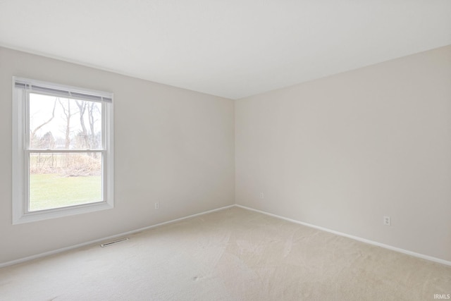 spare room featuring light colored carpet