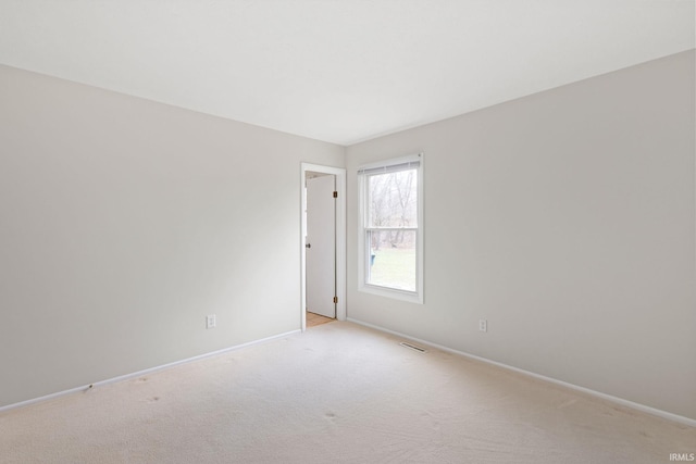 spare room featuring light colored carpet