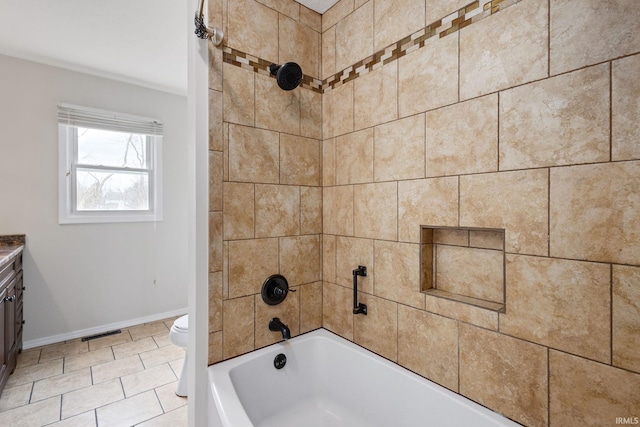 full bathroom featuring vanity, tiled shower / bath, and toilet