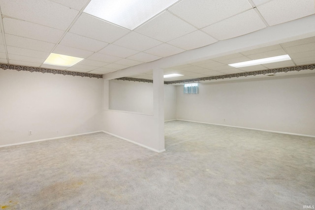 basement featuring carpet flooring and a paneled ceiling