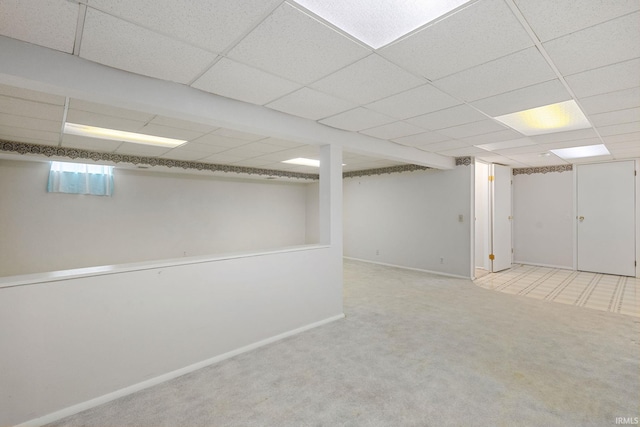 basement with light carpet and a drop ceiling