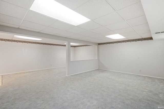 basement with carpet flooring and a drop ceiling