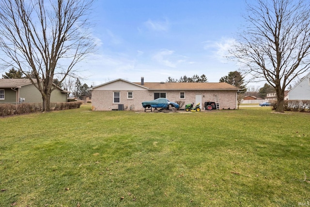 rear view of house with a yard and central AC