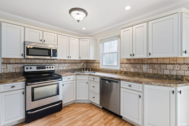 kitchen featuring stainless steel appliances, white cabinetry, sink, and backsplash