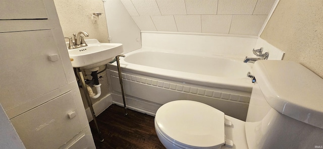 519 W 5th St, Mount Carmel, IL 62863 - bathroom with sink, hardwood / wood-style flooring, a tub, and toilet