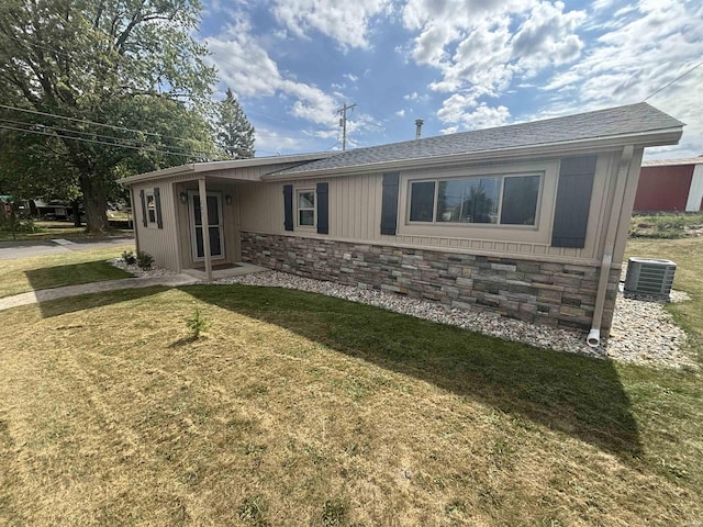 exterior space with central AC and a lawn