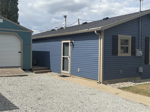 exterior space featuring a garage and an outbuilding