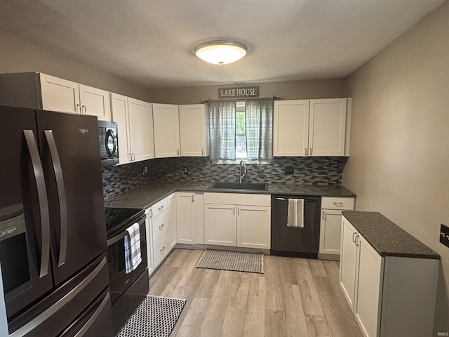 kitchen featuring sink, black appliances, white cabinets, and light wood-type flooring