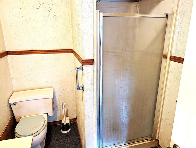 bathroom featuring an enclosed shower and toilet