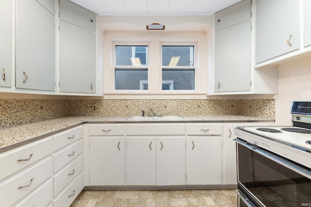 kitchen with white cabinetry, sink, electric range oven, and decorative backsplash