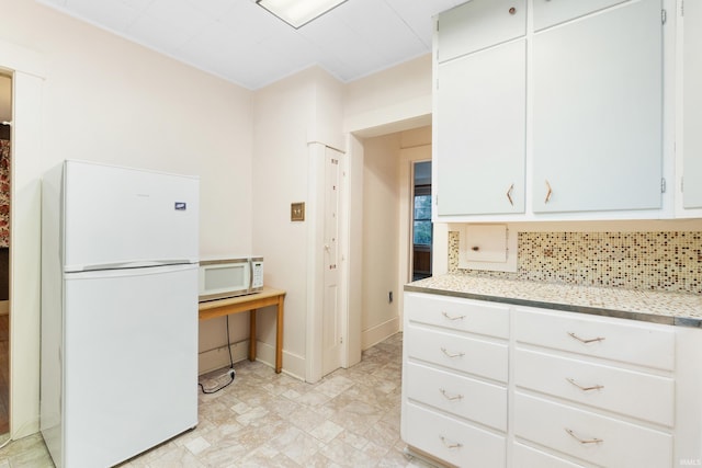 kitchen featuring backsplash, white cabinets, and white appliances