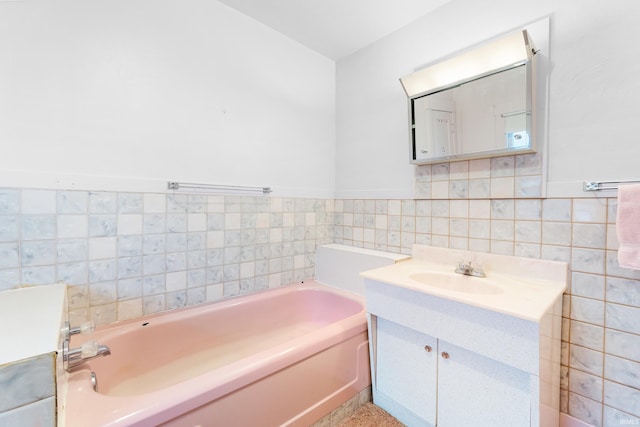 bathroom featuring a bathing tub, tile walls, and vanity