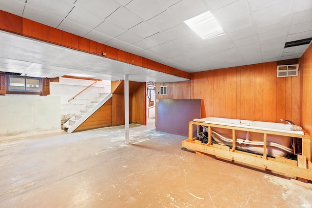 basement with wooden walls and a wall unit AC