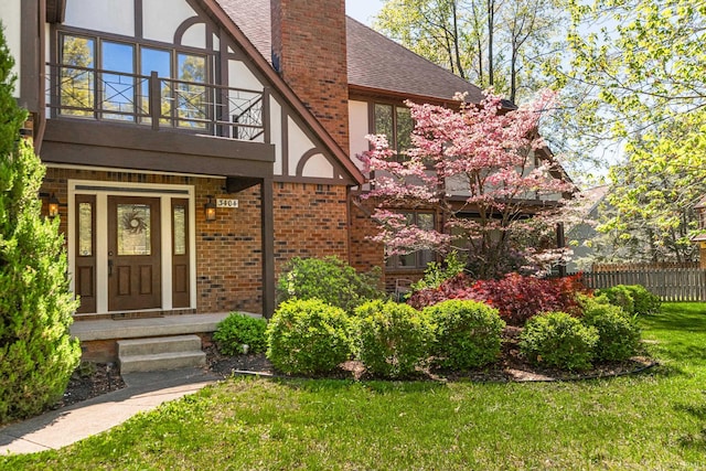 doorway to property featuring a balcony and a yard