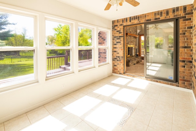 unfurnished sunroom with ceiling fan